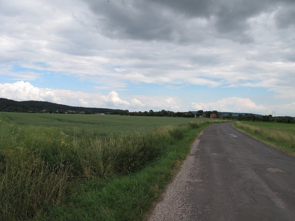 Široká zpevněná cesta krajinou vhodná pro kočárek